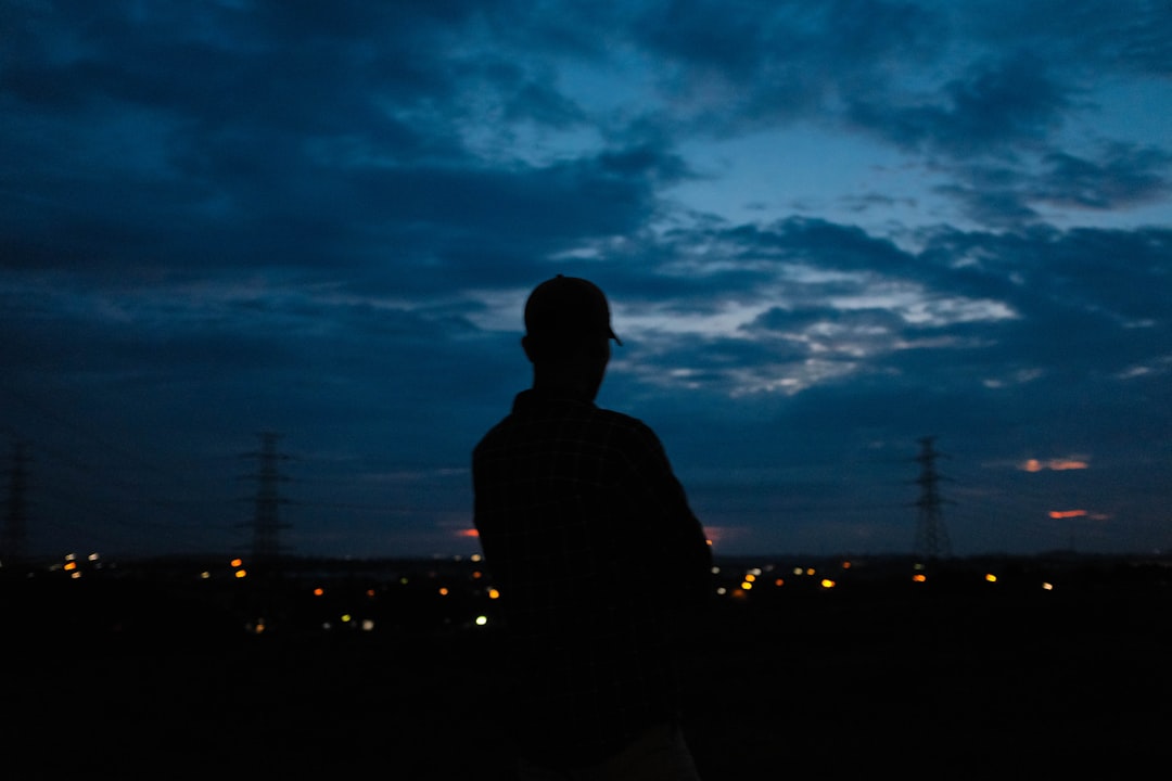a man standing in the dark with a cell phone in his hand