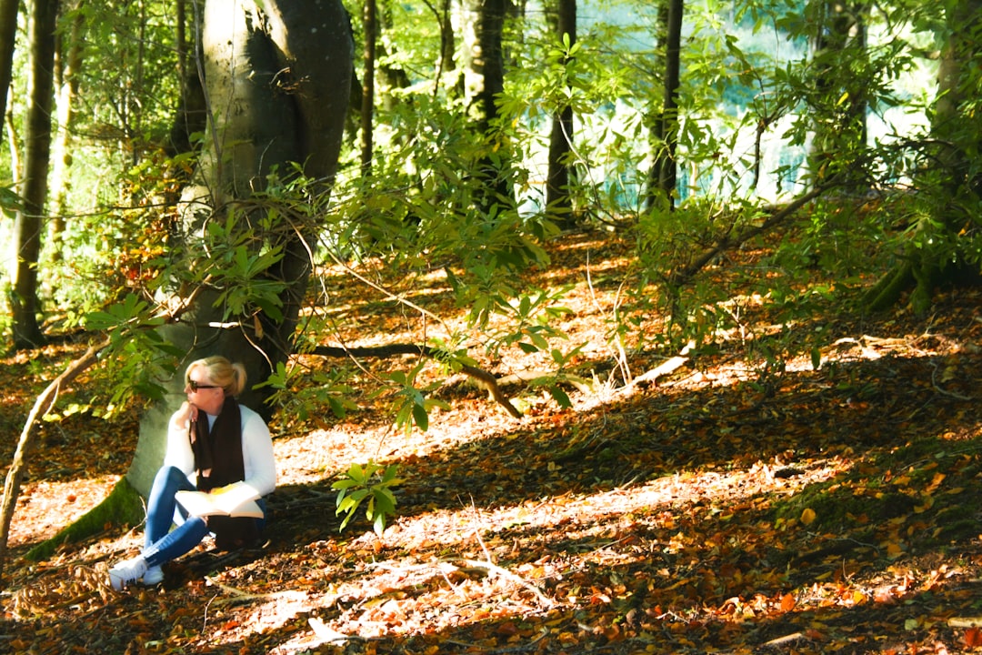 A woman sitting on the ground in the woods