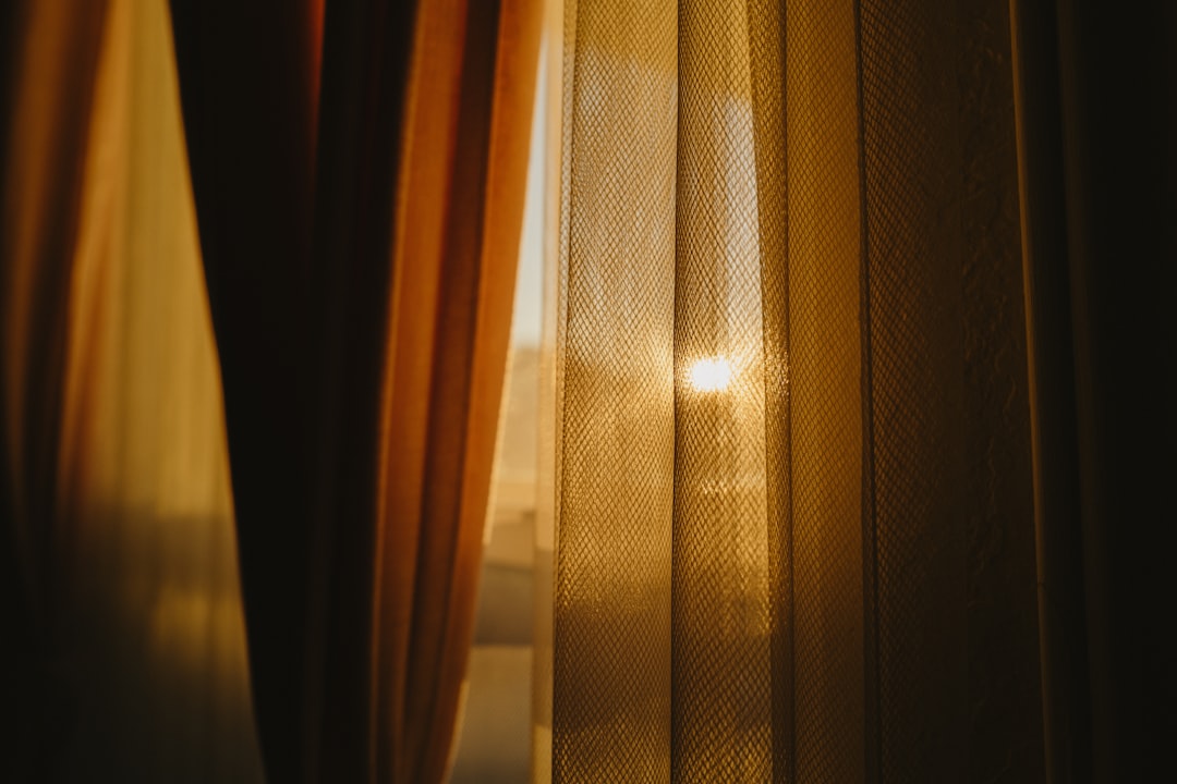 the sun is shining through the curtains of a window
