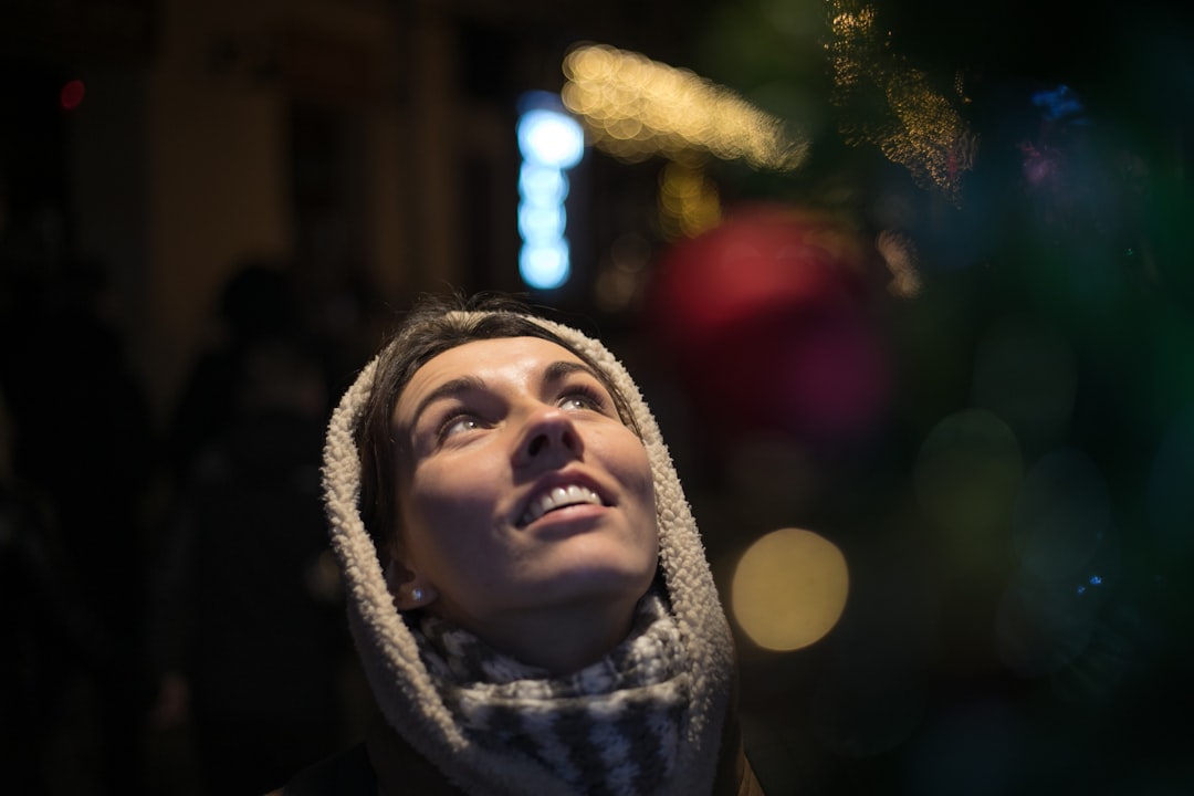 a woman looking up at a christmas tree